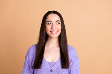 Portrait of nice young woman look empty space wear cardigan isolated on beige color background