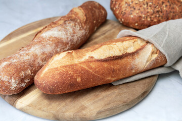 Two fresh baguettes on a cutting board. High quality photo