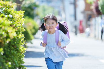 小学校に登校する走る小学生