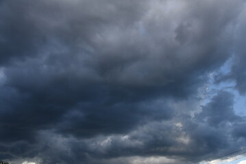 Fototapeta premium Dramatic dark storm rain clouds black sky background. Dark thunderstorm clouds rainny atmosphere. Meteorology danger windstorm disasters climate. Dark cloudscape storm disaster gloomy gray cloud sky