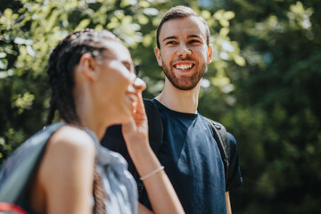 Naklejka premium A cheerful young couple smiling and enjoying a hike in a verdant forest. Capturing the joy and connection of outdoor adventures.