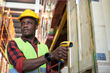 African worker using barcode scanner at the warehouse distribution.  Logistics service business,...