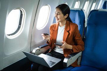 A woman in a formal suit sits in a window seat of an economy class section, looking out the airplane window, ready for her business journey.