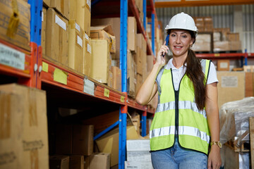 factory worker talking on smartphone to customer in warehouse factory