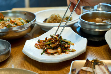 식탁 위의 김치 겉절이를 젓가락으로 집은 모습