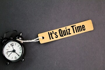clock bells and a piece of paper with the words Its Quiz Time. the concept of answering quizzes or...