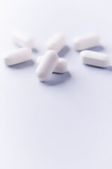 Amino acids tablets. Nutrition for bodybuilding. Fitness supplements on bright paper background. Soft focus. Copy space.