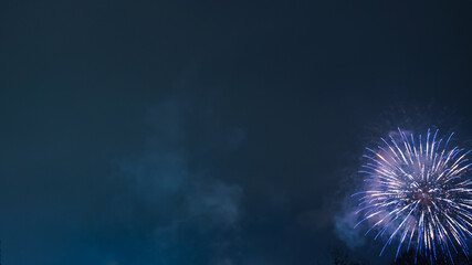 Fireworks exploding in the night sky. Blue and white fireworks create a stunning contrast against...