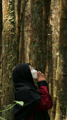 Hijabi Muslimah, serene in forest, finds solace, bowing in prayer, amidst nature's embrace