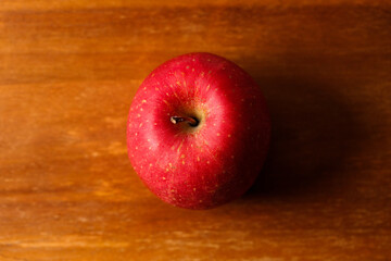 Ripe organic red apple on wooden table background.