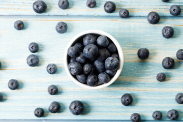 Ripe organic blueberries on blue wooden table background. Selective focus.