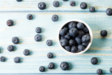 Ripe organic blueberries on blue wooden table background. Selective focus.