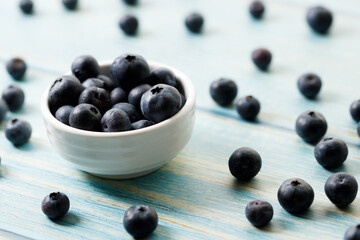 Ripe organic blueberries on blue wooden table background. Selective focus.
