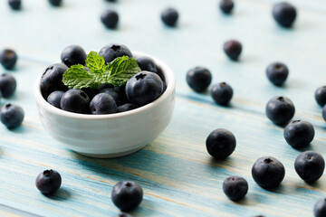 Ripe organic blueberries on blue wooden table background. Selective focus.