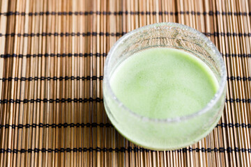 Cup of fresh matcha tea, green tea on wooden table