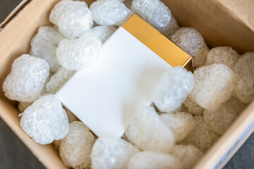 Eco packaging of parcels and white biodegradable filler. Box is filled with a filler safety for environment. Delivery of goods, parcels, delivery service, nature protection and recycling concept