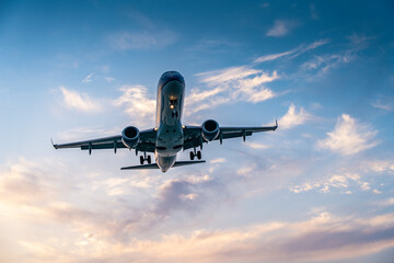 Airplane landing during golden hour with beautiful sky and clouds.Transportation, adventure, and wanderlust.