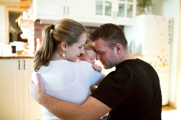 New parents holding newborn baby girl. Unconditional paternal love, idyllic family moment.