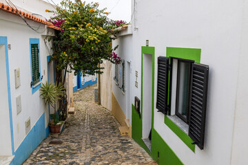 Fototapeta premium Ferragudo, Portugal. 04-20-2024. Colorfull house with flowers at Ferragudo, Algarve, Portugal.
