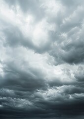 Obraz premium A dramatic cloudscape featuring thick, fluffy storm clouds with soft light filtering through, creating a moody and ethereal atmosphere in the sky.