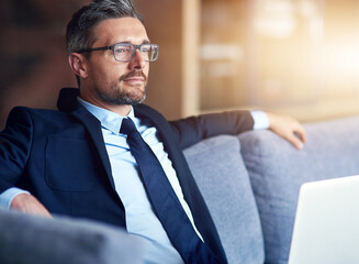 Sofa, relax and businessman with thinking in office for legal case, problem solving and solution. Lawyer, smile and professional person with laptop at law firm for research plan, information and idea