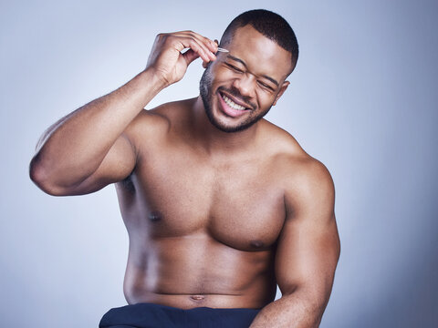 Black man, tweezers and grooming in studio, confident and eyebrows for epilation on blue background. Male person, skincare and maintenance for hygiene routine or cleaning, beauty and facial cosmetics