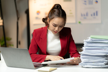Business employee woman working in stacks paper files for checking unfinished achieves busy at work