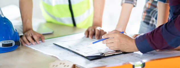 Group of builder team planning and discussing construction home drawing.