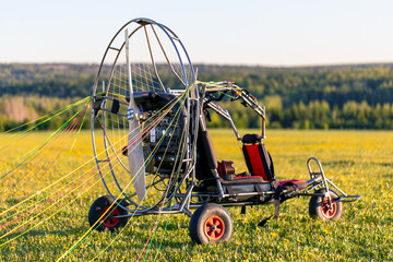 Paragliding machine for paragliding flights on green grass against the bright sun. Preparing...