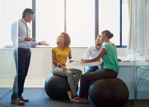 Creative, team and business people with leader for training, coaching or brainstorming in startup office. Group, planning and discussion for strategy, project and editor on fitness ball for exercise
