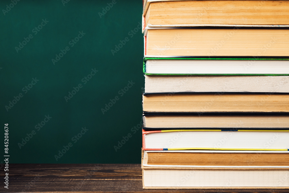 Poster a stack of books on a table with a green background