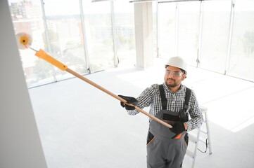 Indian Painter painting the office wall with roller paint