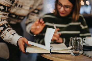 Young adults collaborating on a project in a cozy cafe environment.