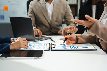 Business team calculate and analyzing graph document financial with laptop and digital tablet in office.