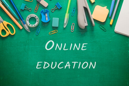 A green chalkboard with a variety of office supplies