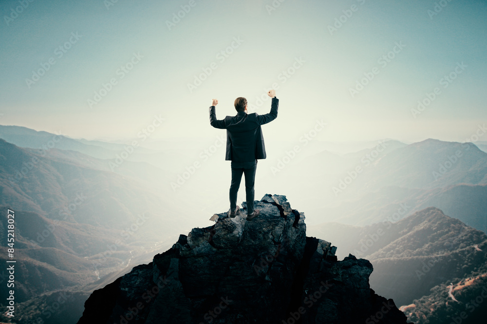Aufkleber back view of young man standing on mountain top and meditating. bright sky background with mock up p