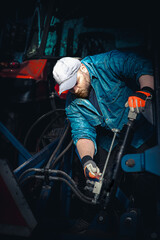 The farmer repairs agricultural machines