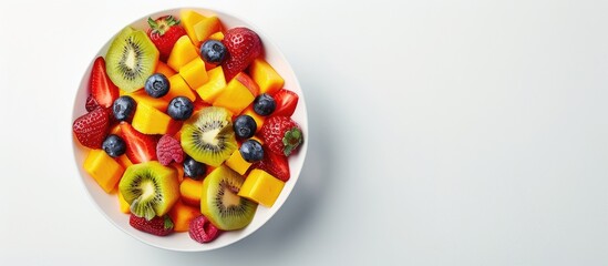 Fresh Fruit Salad Bowl on White Background with Copy Space, Shot from Above.