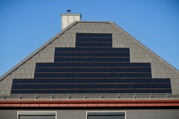 High-tech solar roof tiles on roof as solar power plant. Solar shingles installed on roof of...