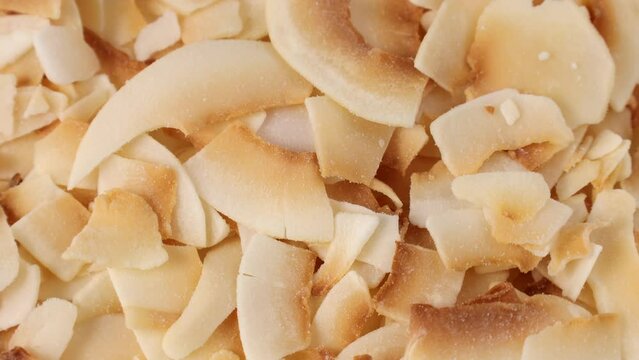 Thin sweet toasted coconut chips circle rotation close up top view