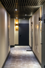 Illuminated corridor in a modern residential building. Illuminated apartment numbers