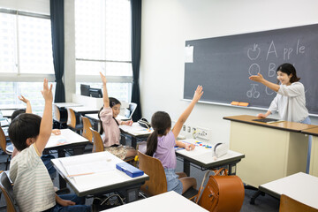 日本の小学校の教室で英語の授業をする様子　先生と子どもたち