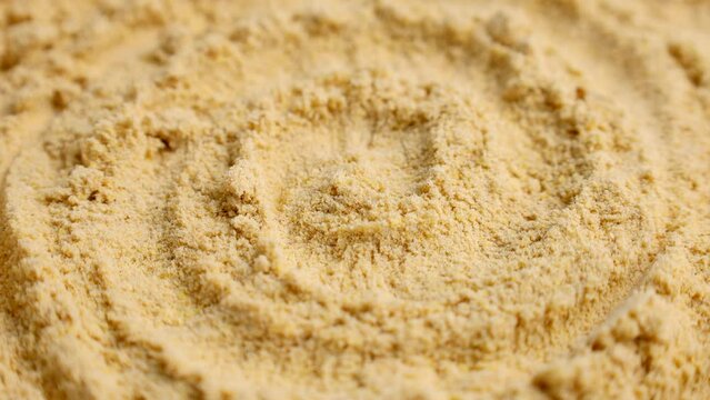 Ground dry ginger root spice powder circle rotation close up