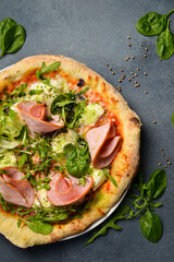Traditional pizza with boiled sausage, arugula and sauce. Top view.