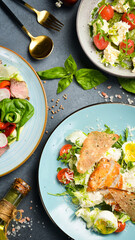 A full table of food, dishes and snacks. Food in plates on a stone background. Top view.