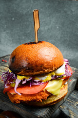 Juicy burger with cutlet, cheese and vegetables. Fast food.