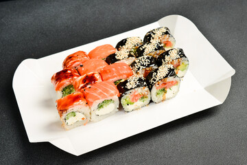 Sushi delivery box. Japanese salmon set menu in black transparent box. Top view.