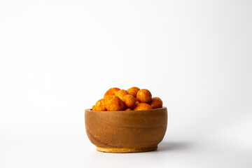 Baked bean snacks give a delicious taste and are crispy yet spicy, with a wooden bowl base on a white background