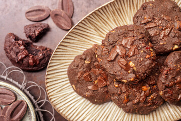 double chocolate cookies in ceramic plate on rusty background.