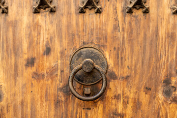 Antique brass door knocker in the shape, door element with metal knob. A old door handle on a vintage wooden door, Details